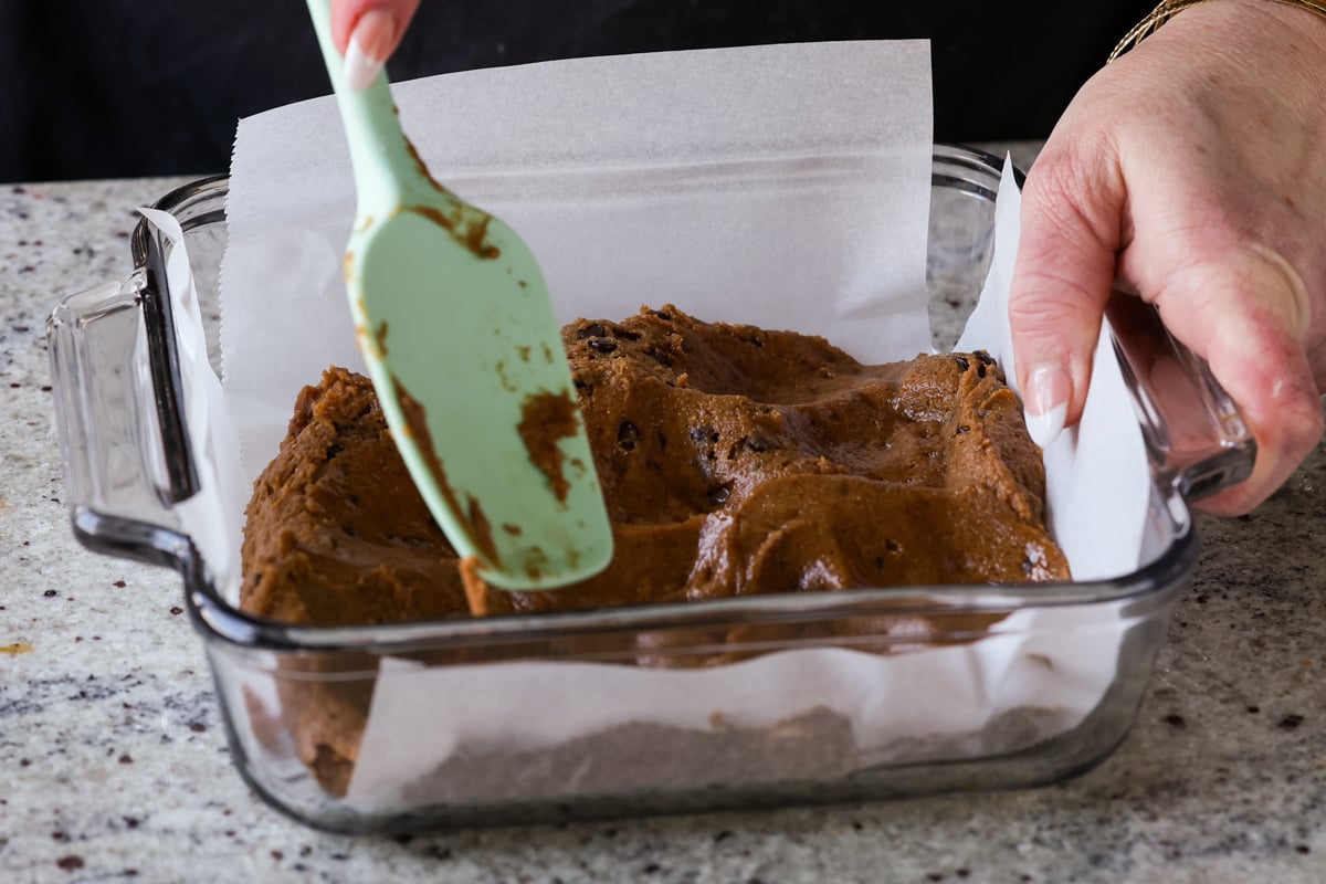 pressing vegan blondies batter in the baking pan to even it out