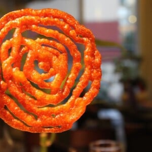 A jalebi being held towards the camera