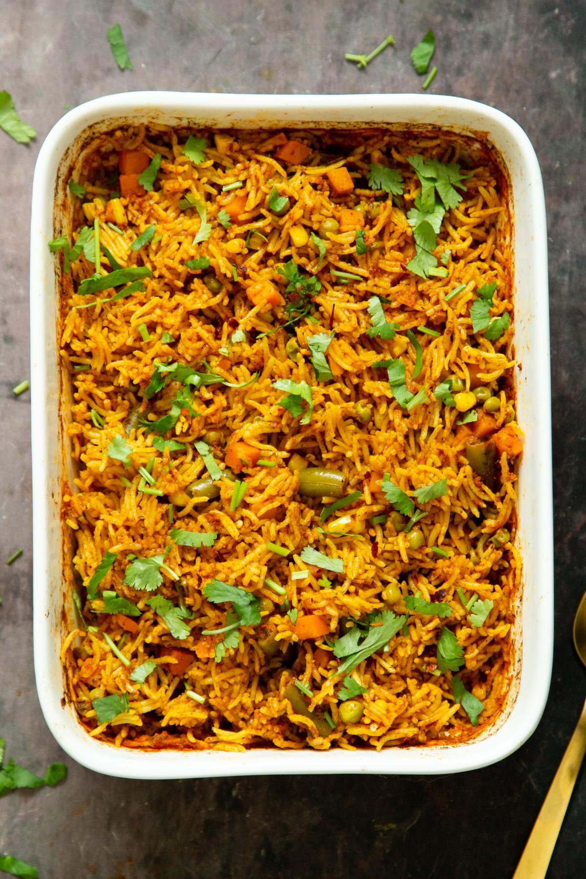 a casserole dish with baked masala rice 