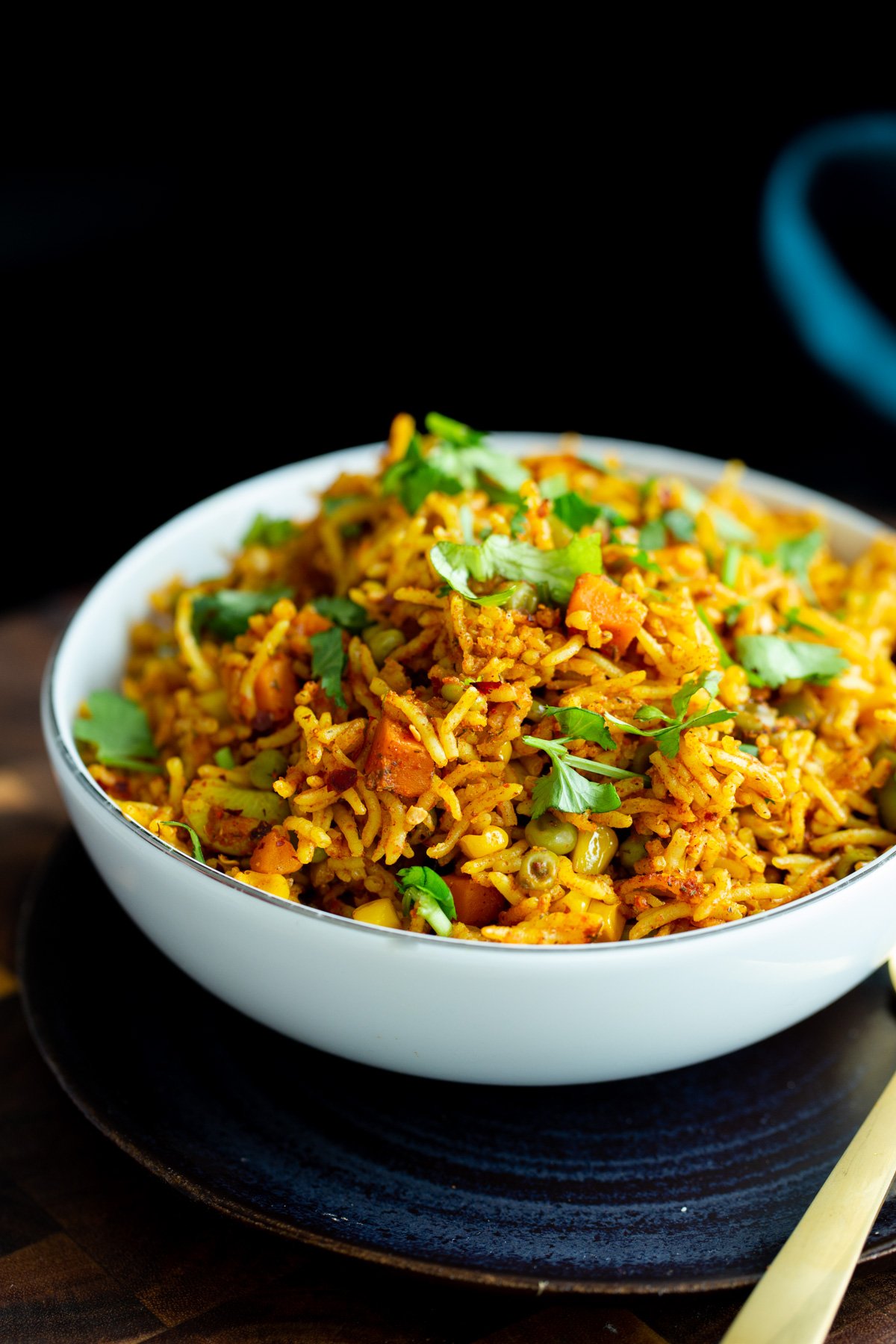 a small bowl with vegan masala rice casserole sprinkled with chopped cilantro