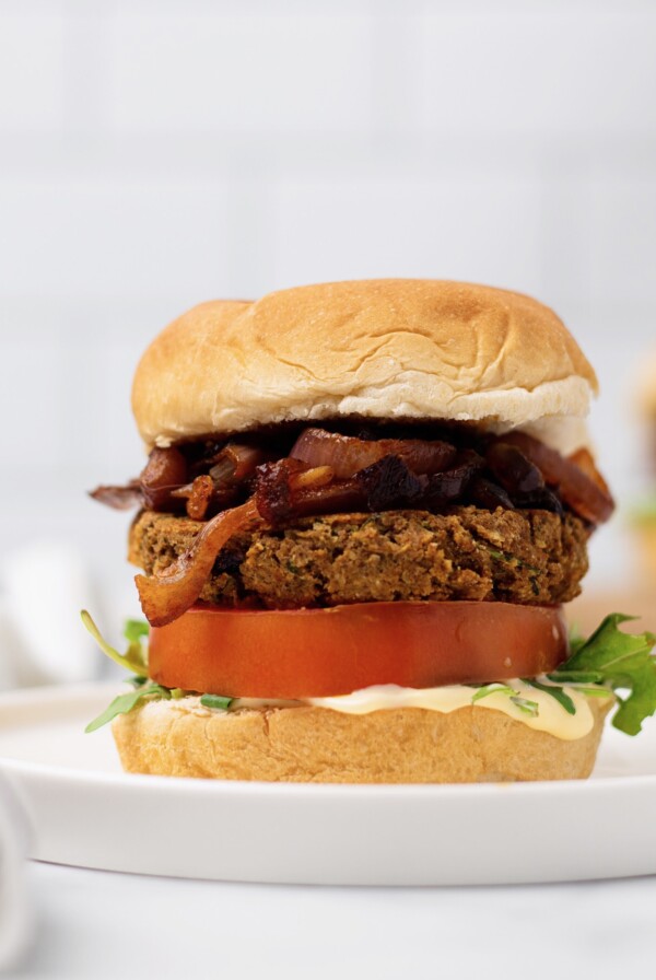 side view if vegan chickpea burger with caramelized onions and hummus