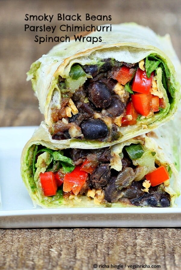 a healthy vegan wrap cut in half revealing a black bean and spinach filling