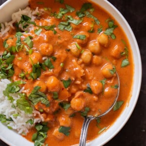 close-up of a bowl of butter chickpeas over rice with cilantro on top