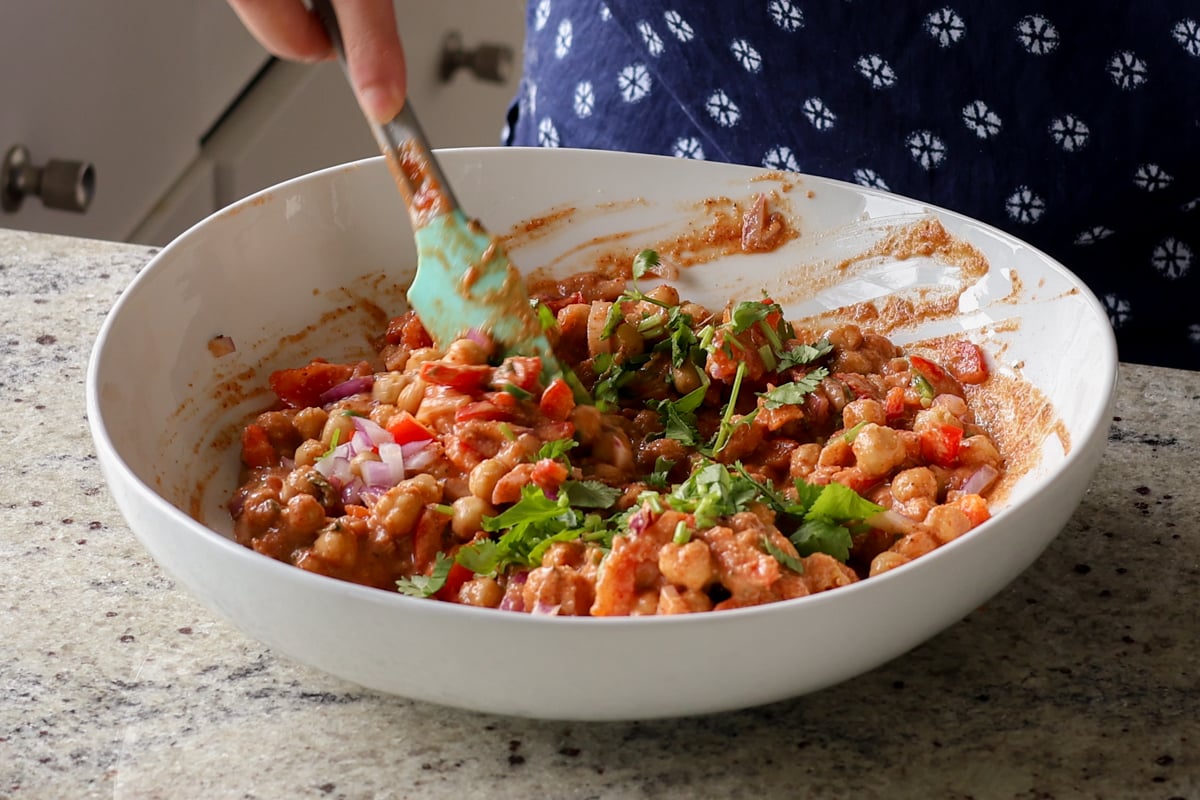 mixing the chickpeas and veggies into the sauce