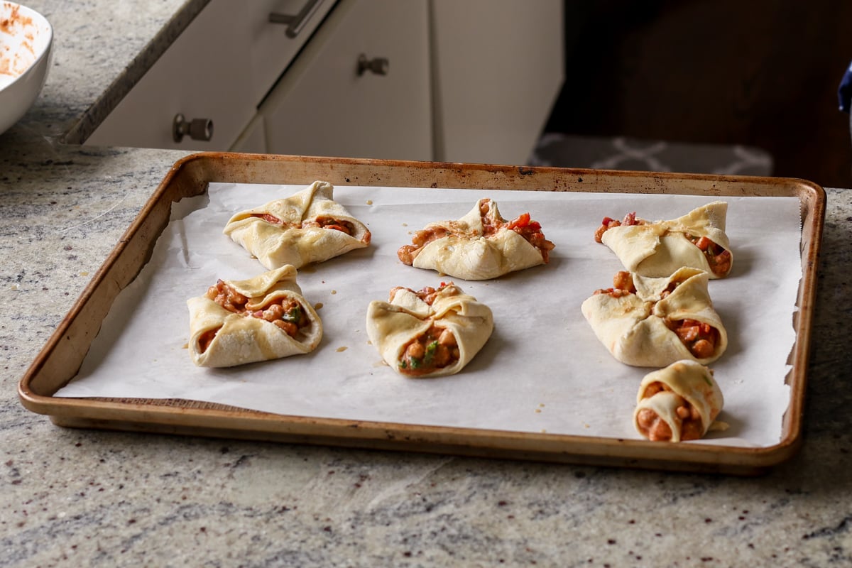 folded chickpea tikka masala puffs on the baking sheet