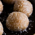 close-up of toasted coconut ladoo on a black plate