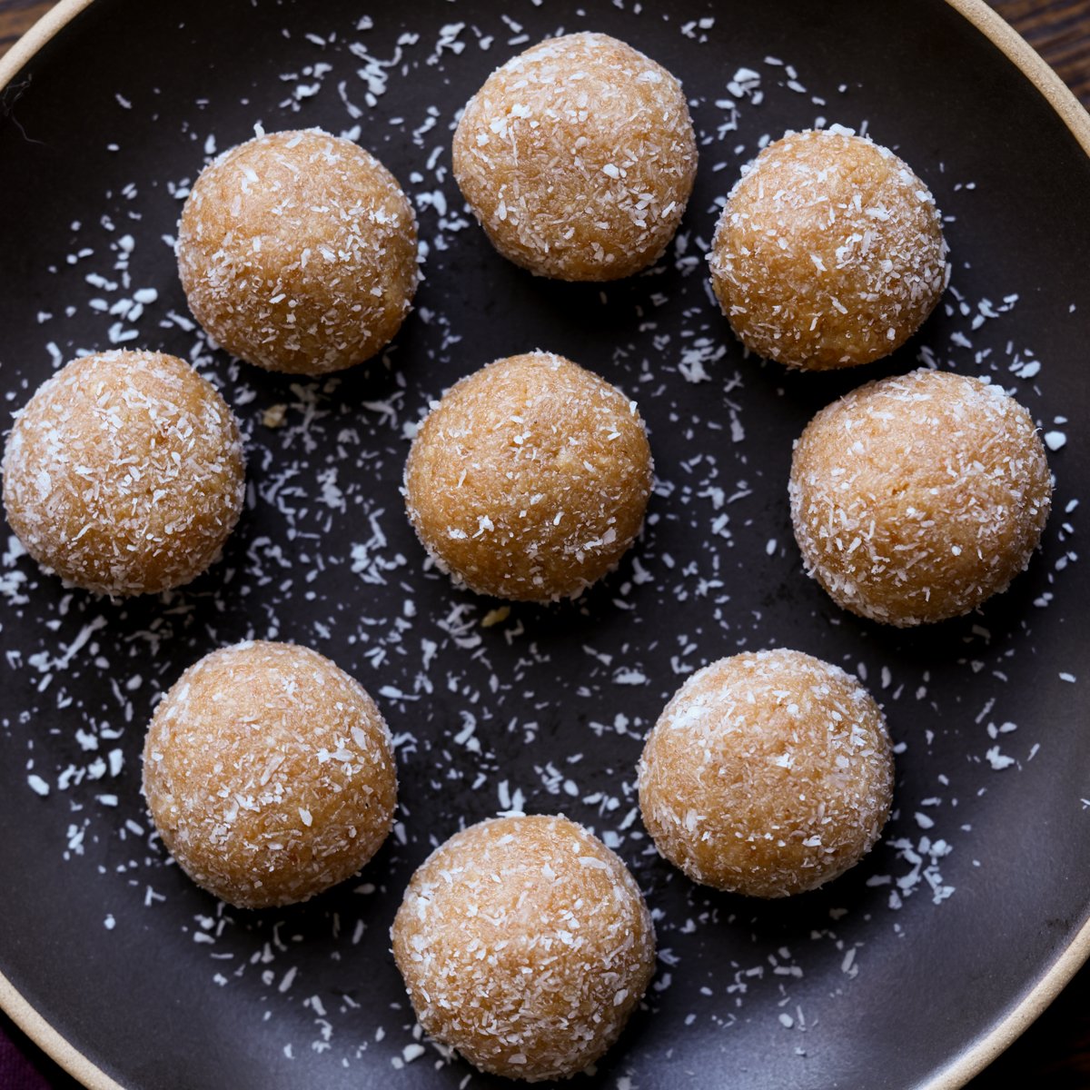 toasted coconut ladoo on a black plate