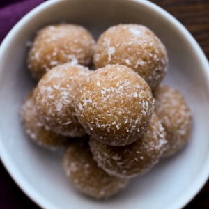 close-up of toasted coconut ladoo on a white serving plate