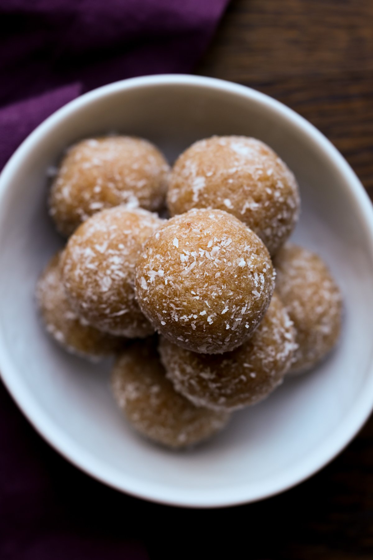 close-up of toasted coconut ladoo on a white serving plate