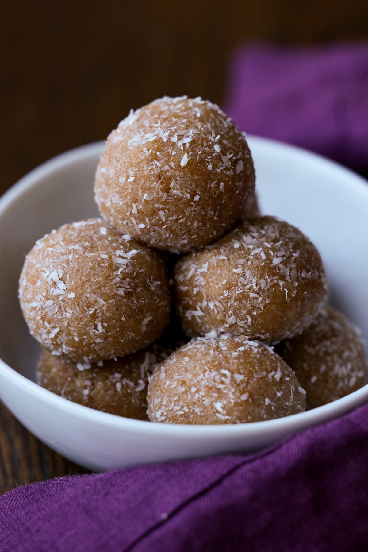 pile of toasted coconut ladoo on a white serving plate