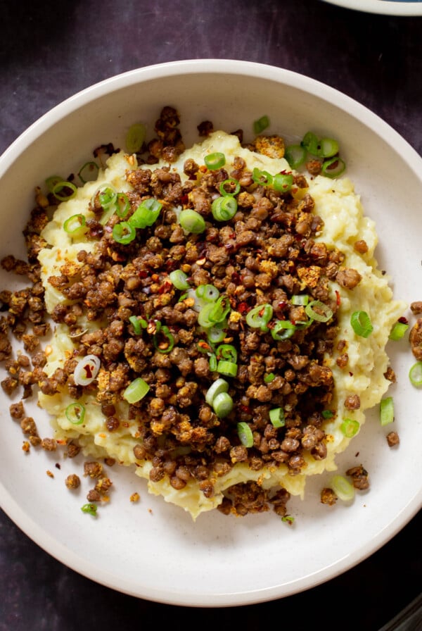 lentil mashed potatoes in a bowl with green onions on top