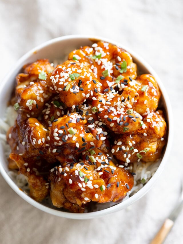 Vegan Sticky Sesame Cauliflower over rice in a white bowl