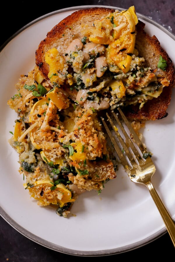 delicata squash casserole on a plate next to the casserole dish