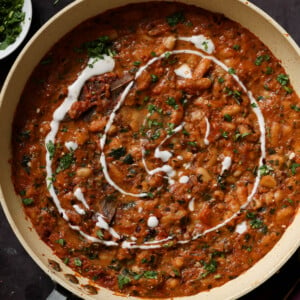 Dhaba chicken white beans in the pan topped with pepper flakes, cilantro, and non-dairy yogurt