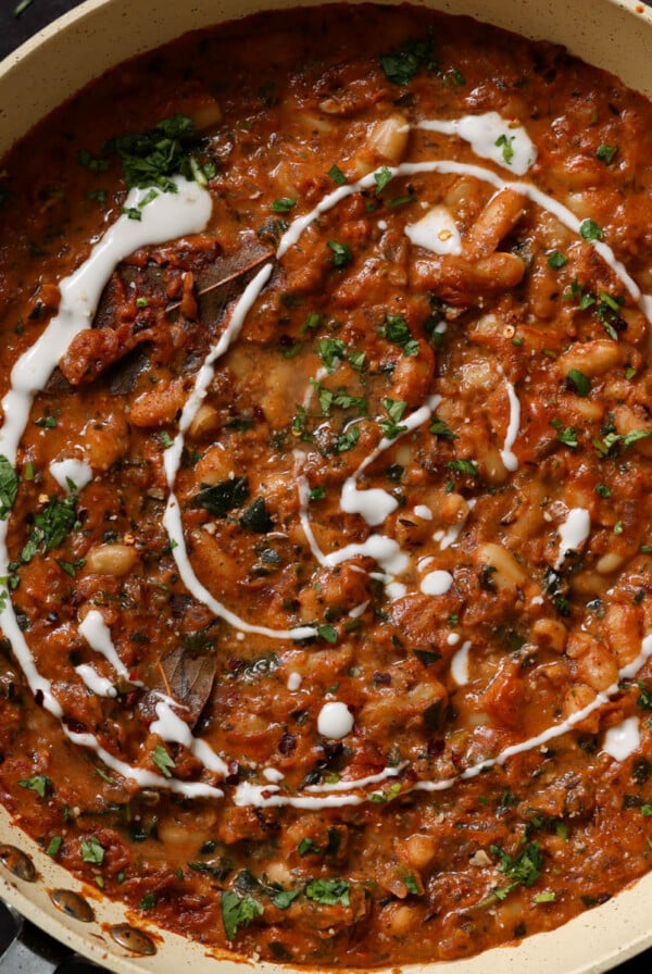 Dhaba chicken white beans in the pan topped with pepper flakes, cilantro, and non-dairy yogurt