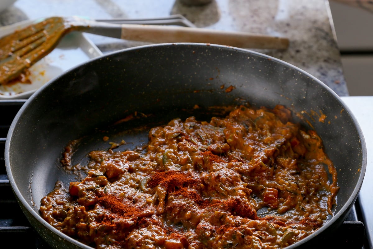 adding ground spices to the sauce