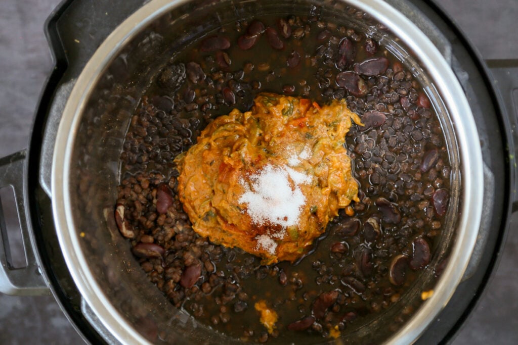 adding yogurt, sauce,  and spices to the cooked dal