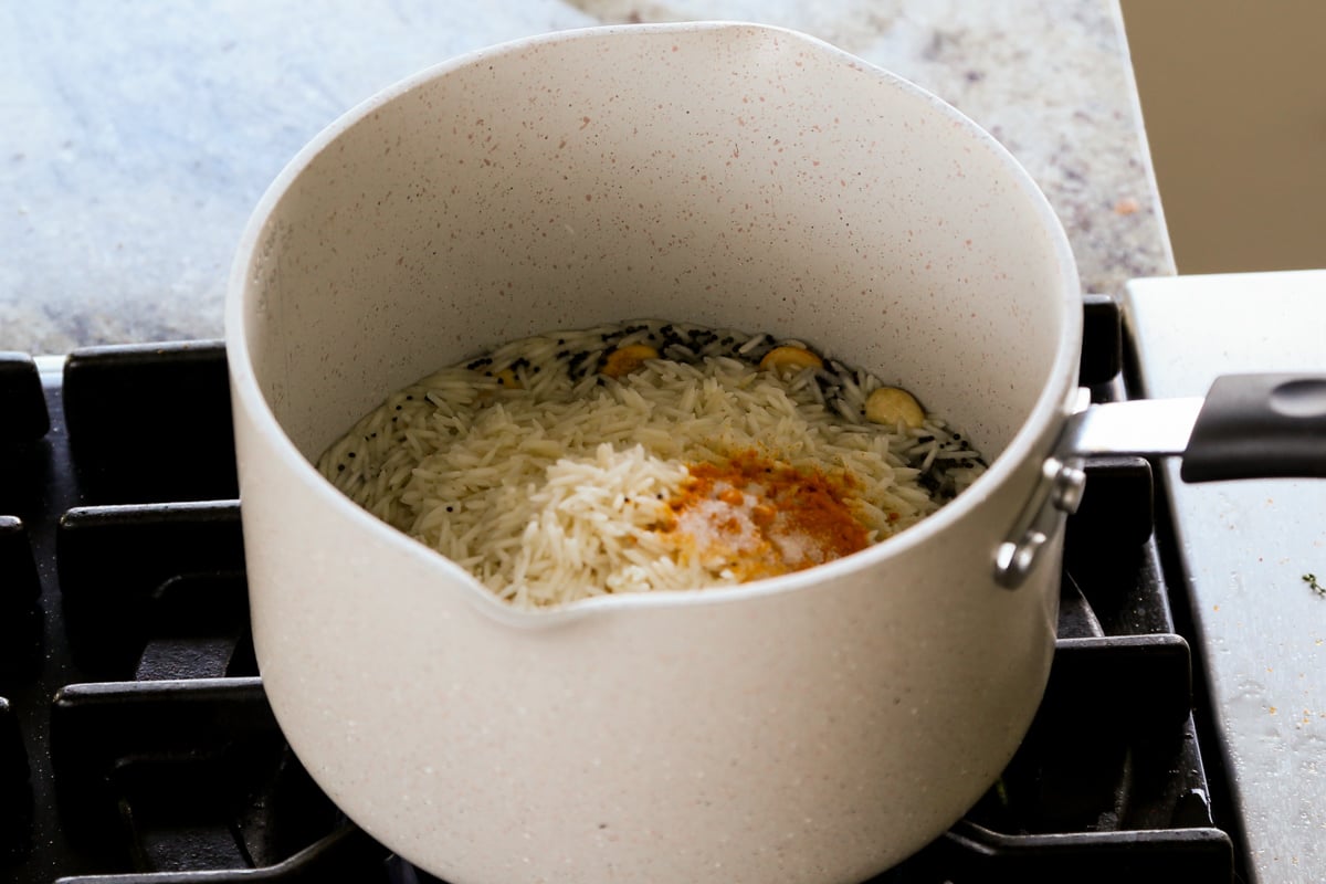 adding rice and spices to the pan