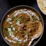 makhani dal in a serving bowl with cashew cream and cilantro on top