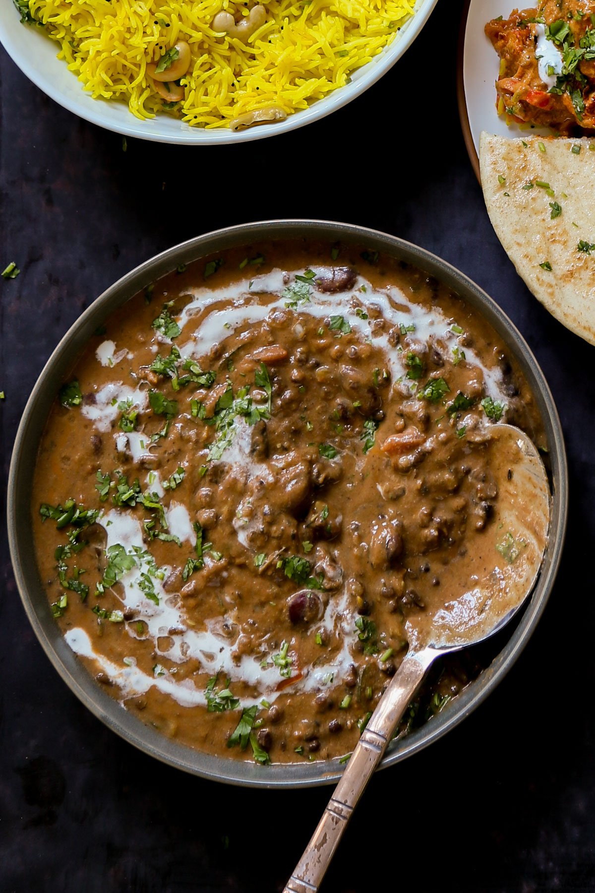 makhani dal in a serving bowl with cashew cream and cilantro on top