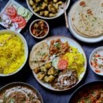 no onion no garlic Diwali menu on serving plates and one dinner plate with all the dishes