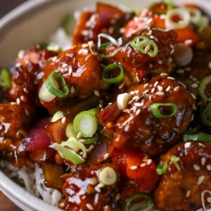 close-up of General Tso's tofu in a bowl with green onion and sesame seeds