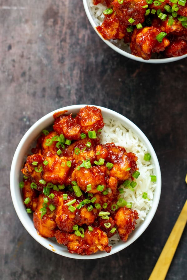 gochujang cauliflower wings in bowls with rice and green onions