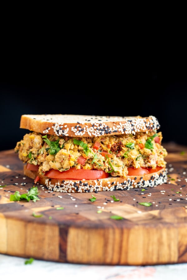 Mediterranean chickpea salad sandwich on a wooden board