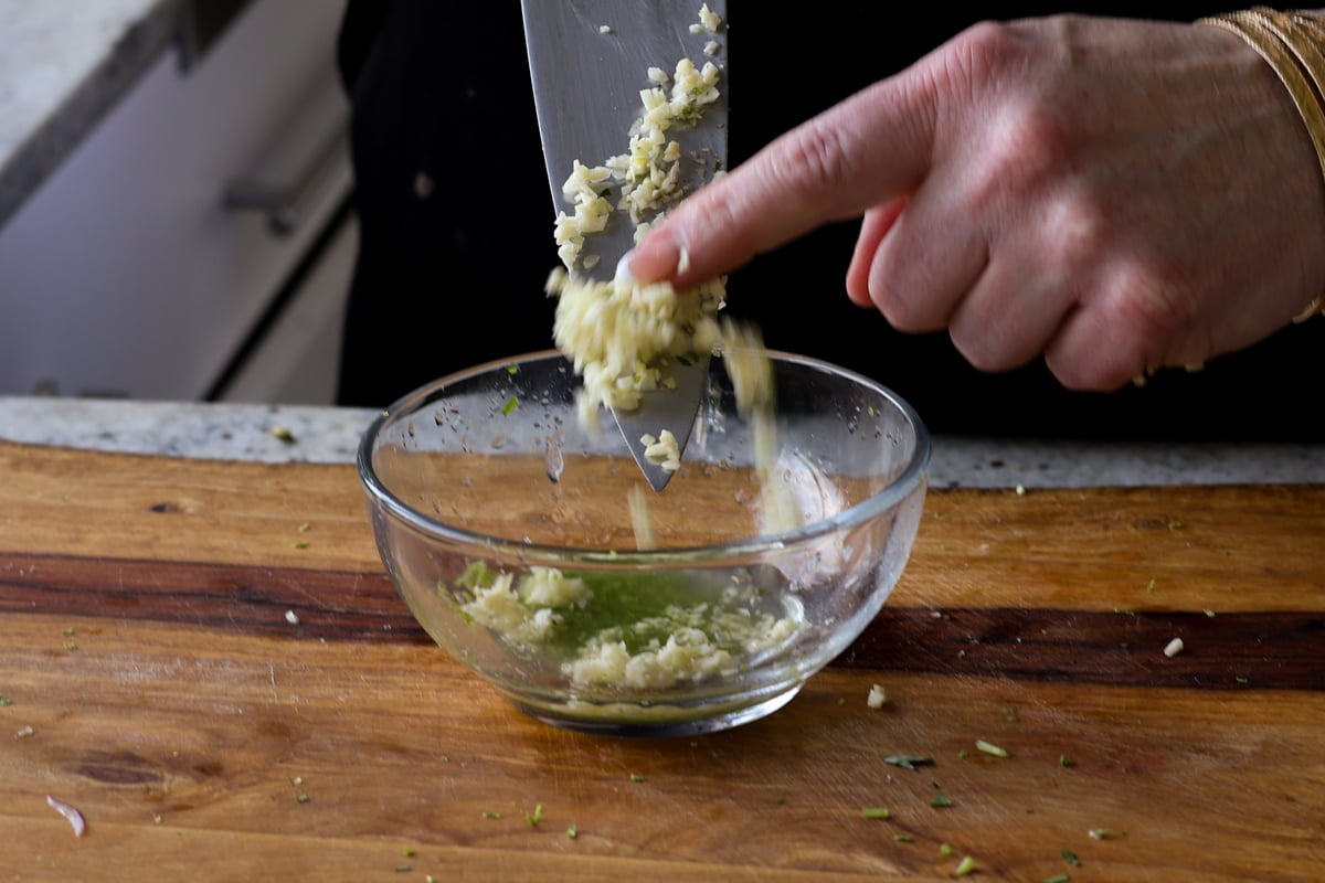 adding minced garlic to the bowl