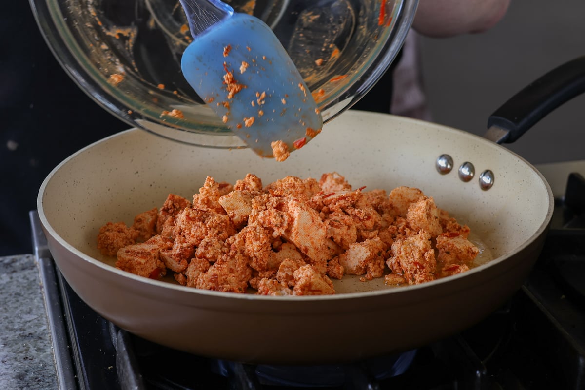 adding the harissa tofu to the pan