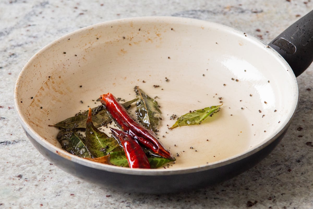 curry leaves and chili in a sauteeing pan 