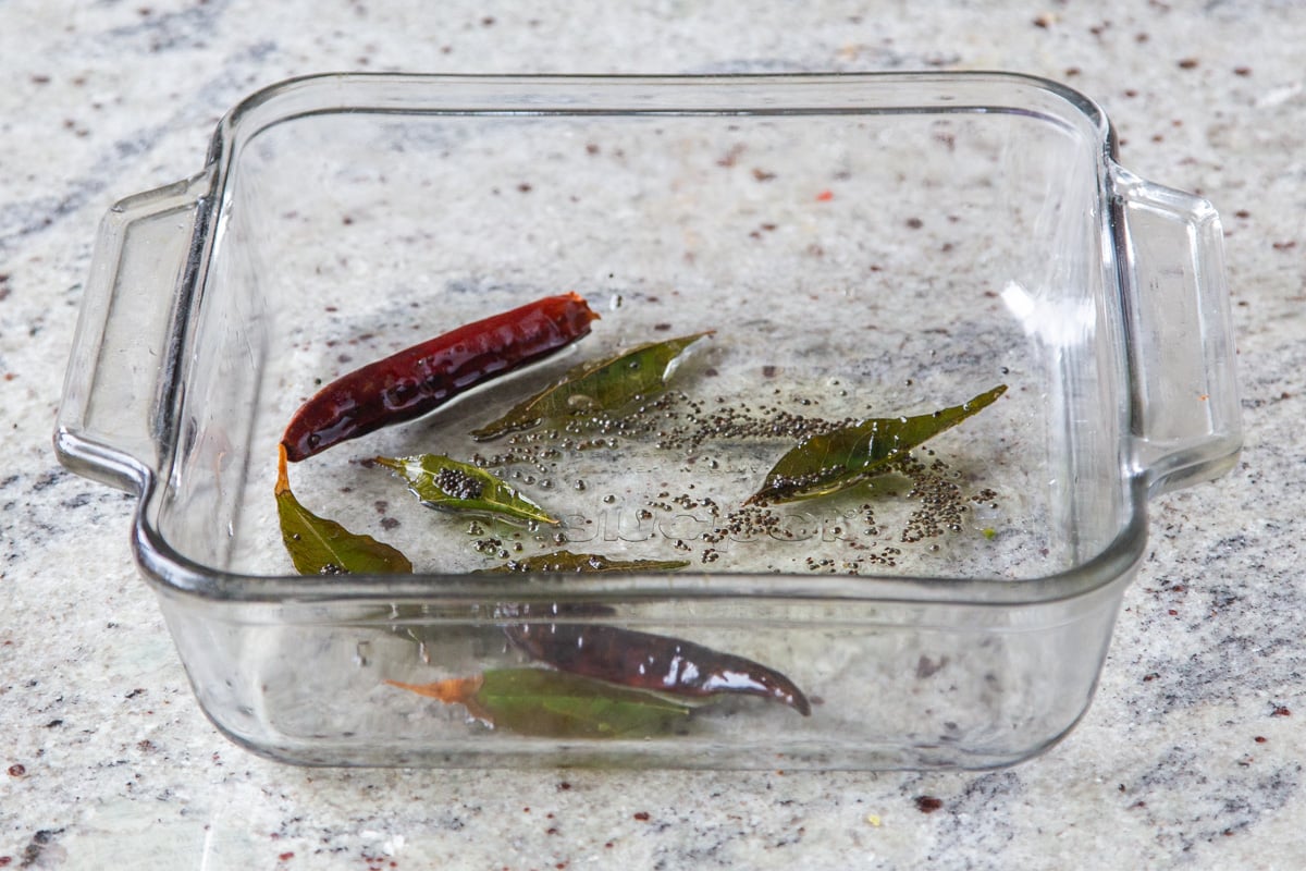 chili and curry leaves in a glass casserole dish 