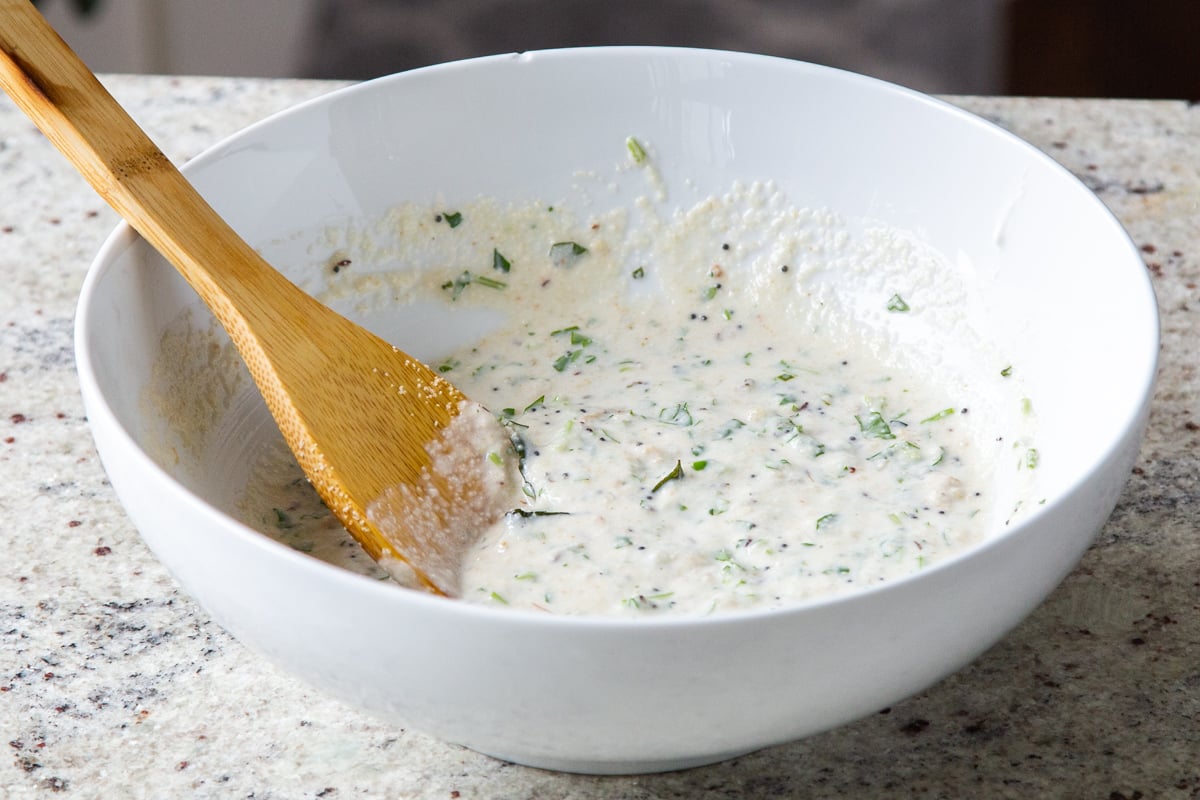 idli batter in a white bowl