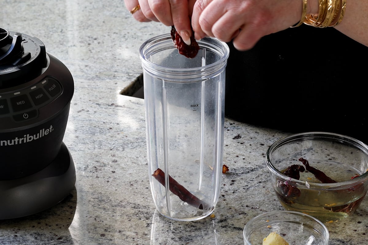 adding soaked chilis to the blender