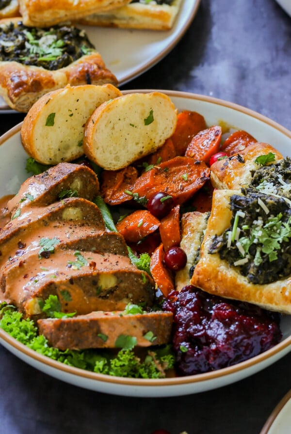 chickpea loaf on a plate as part of a vegan Indian Thanksgiving spread