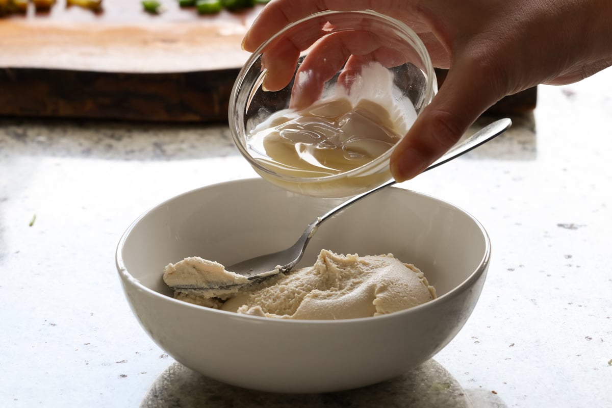 adding non-dairy yogurt to the mixing bowl