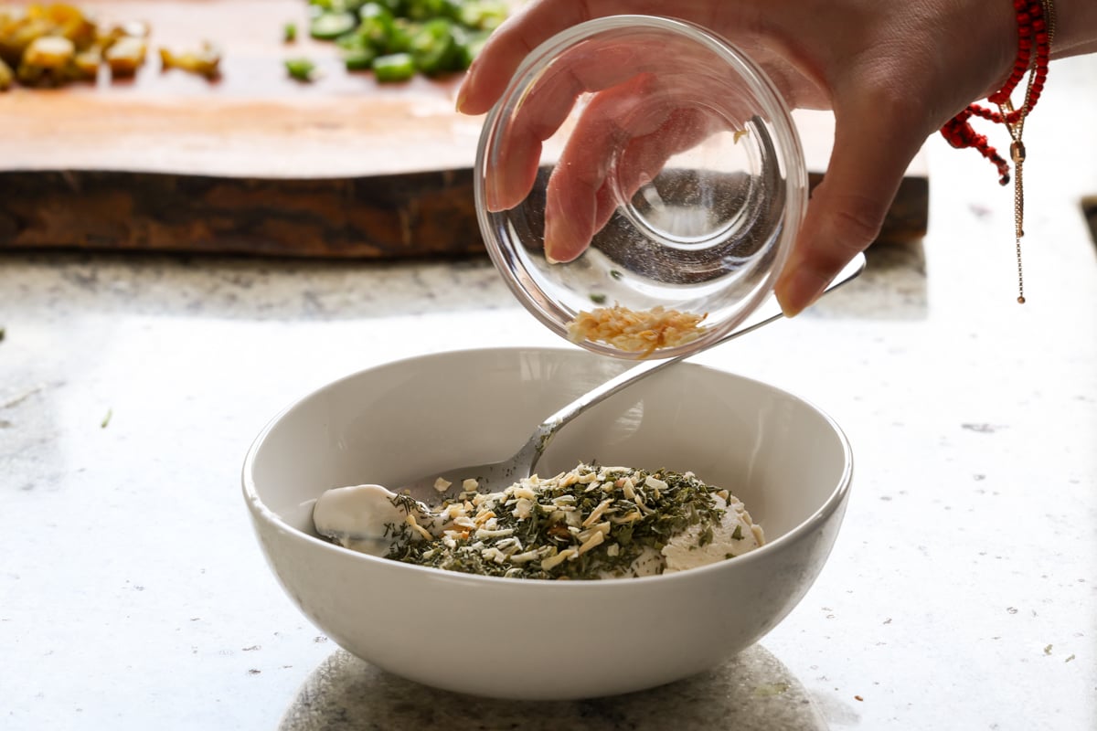 adding onion to the mixing bowl