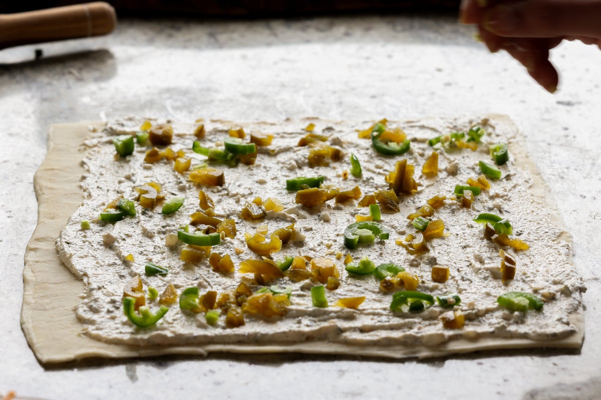 sprinkling the jalapeños over the puff pastry