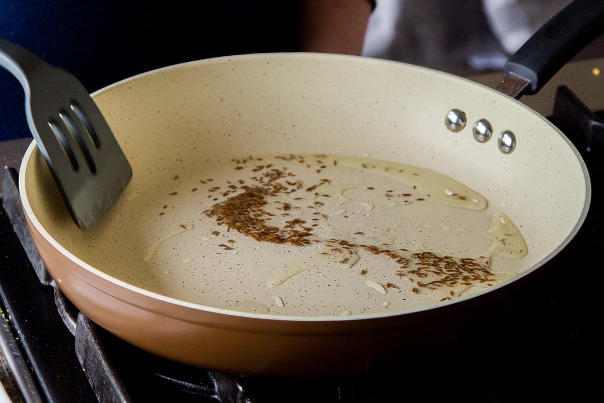 toasting cumin seeds in the frying pan