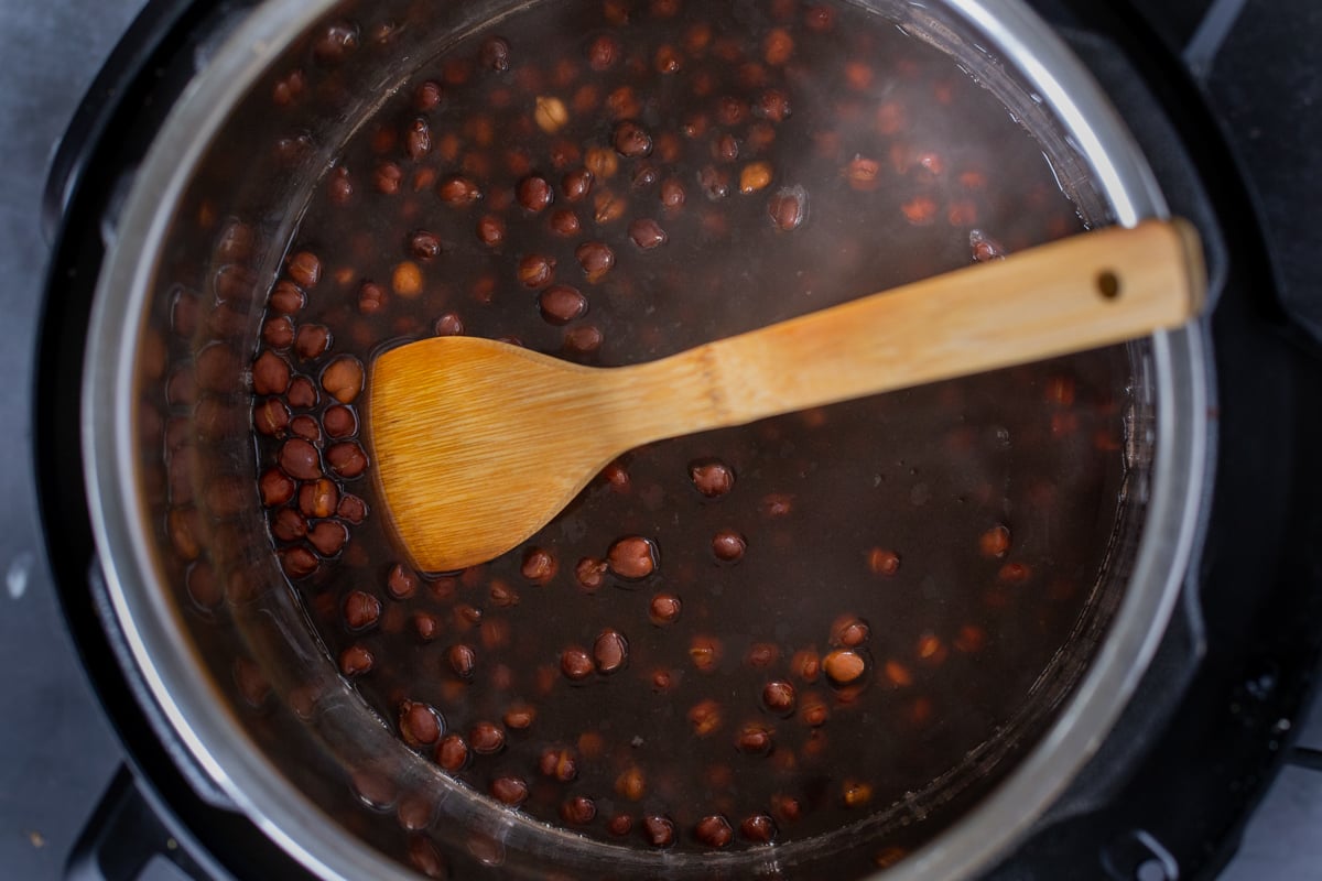 brown chickpeas and water in the Instant Pot, after cooking