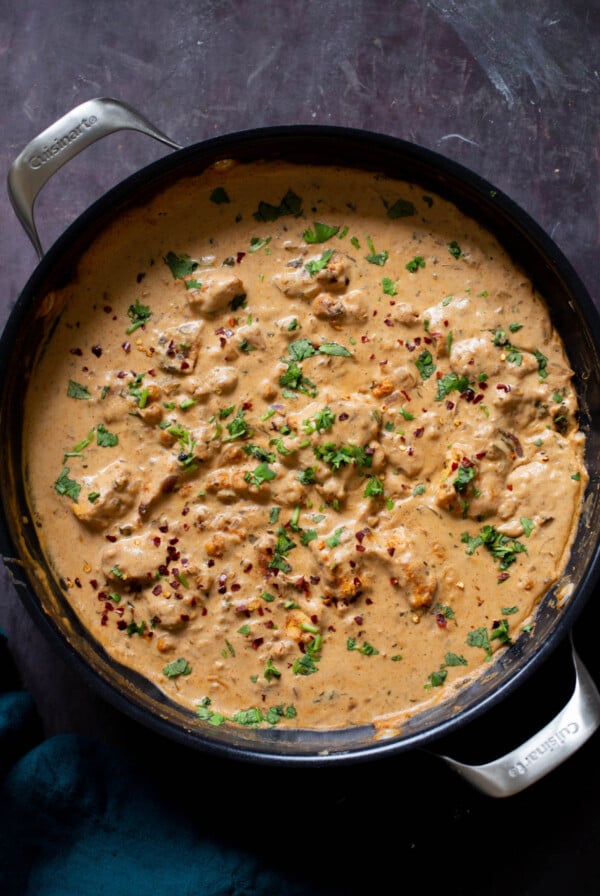 vegan kasuri malai murg in the pan, after cooking with fresh herbs sprinkled on top