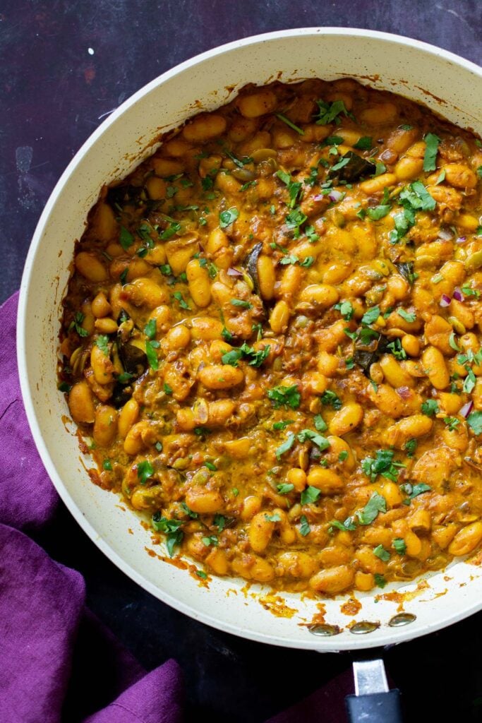 pan of spicy white bean stew with cilantro garnish