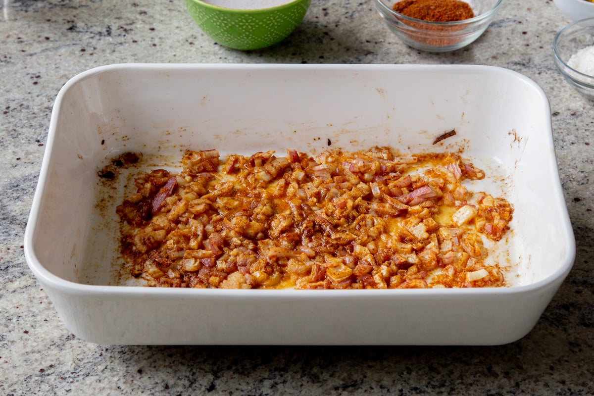 adding onion, ginger, and garlic mixed with the spices in the baking pan, after baking