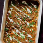 Konkani curry dal casserole topped with coconut cream, cilantro, and pepper flakes in the baking pan