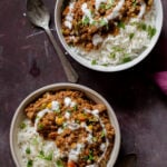 bowls of baked Konkani curry topped with coconut cream, cilantro, and pepper flakes