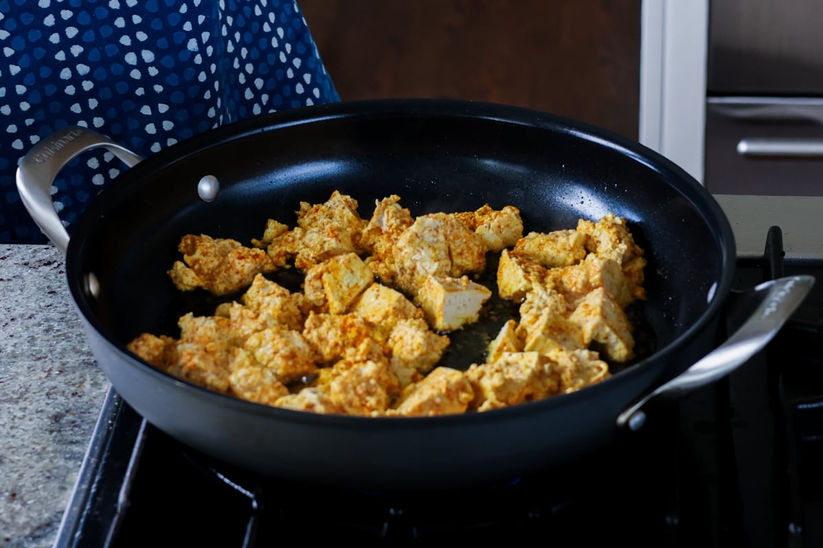 adding tofu to the pan