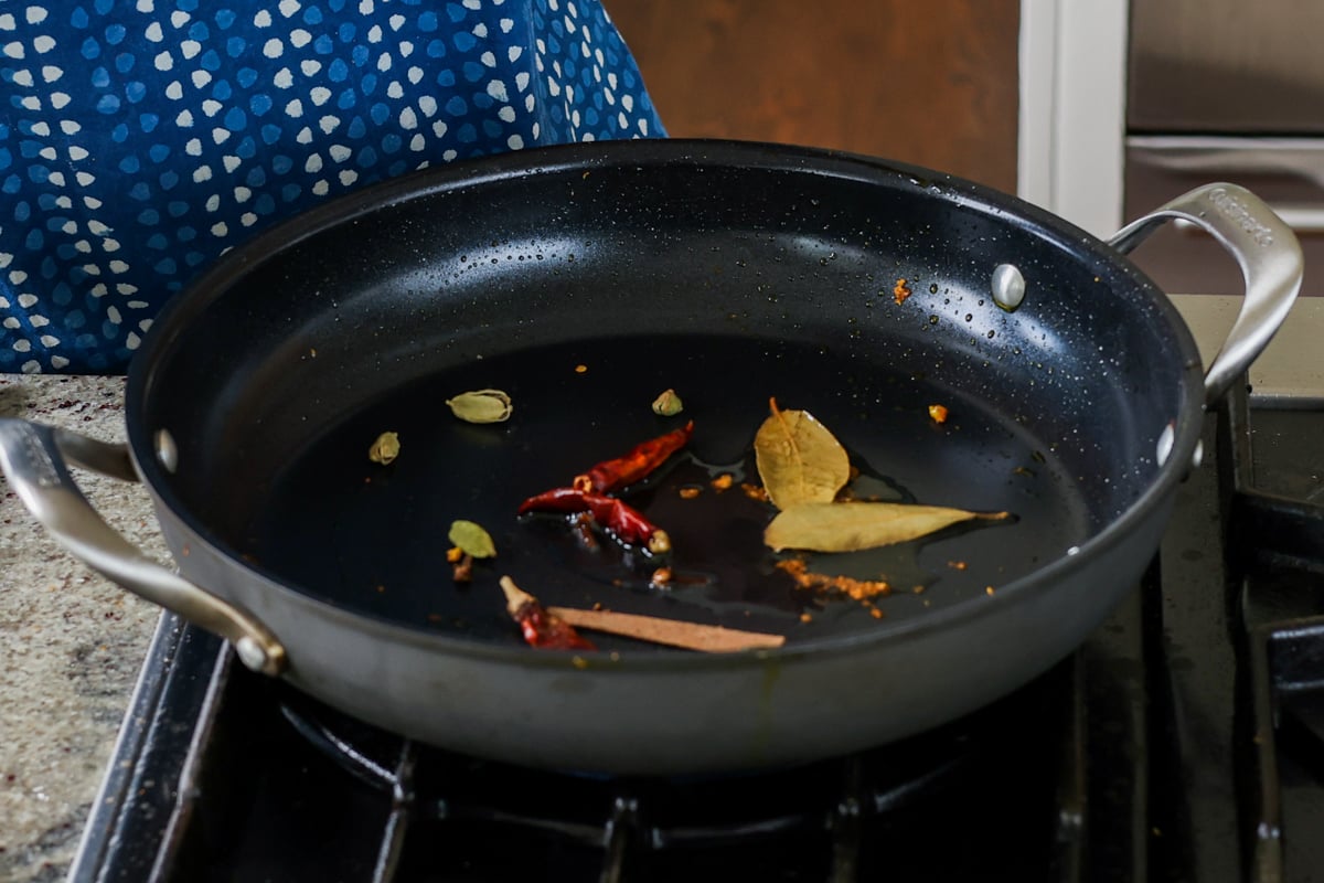 adding whole spices to the pan