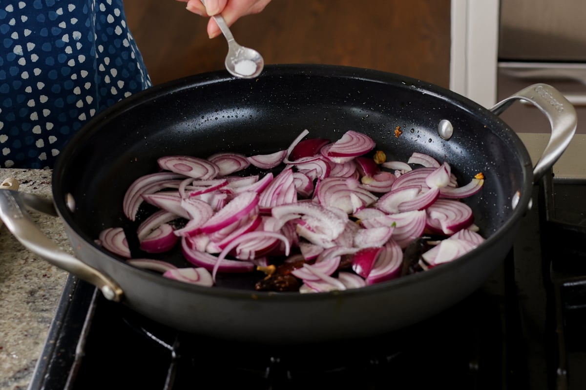 adding onion and salt to the pan