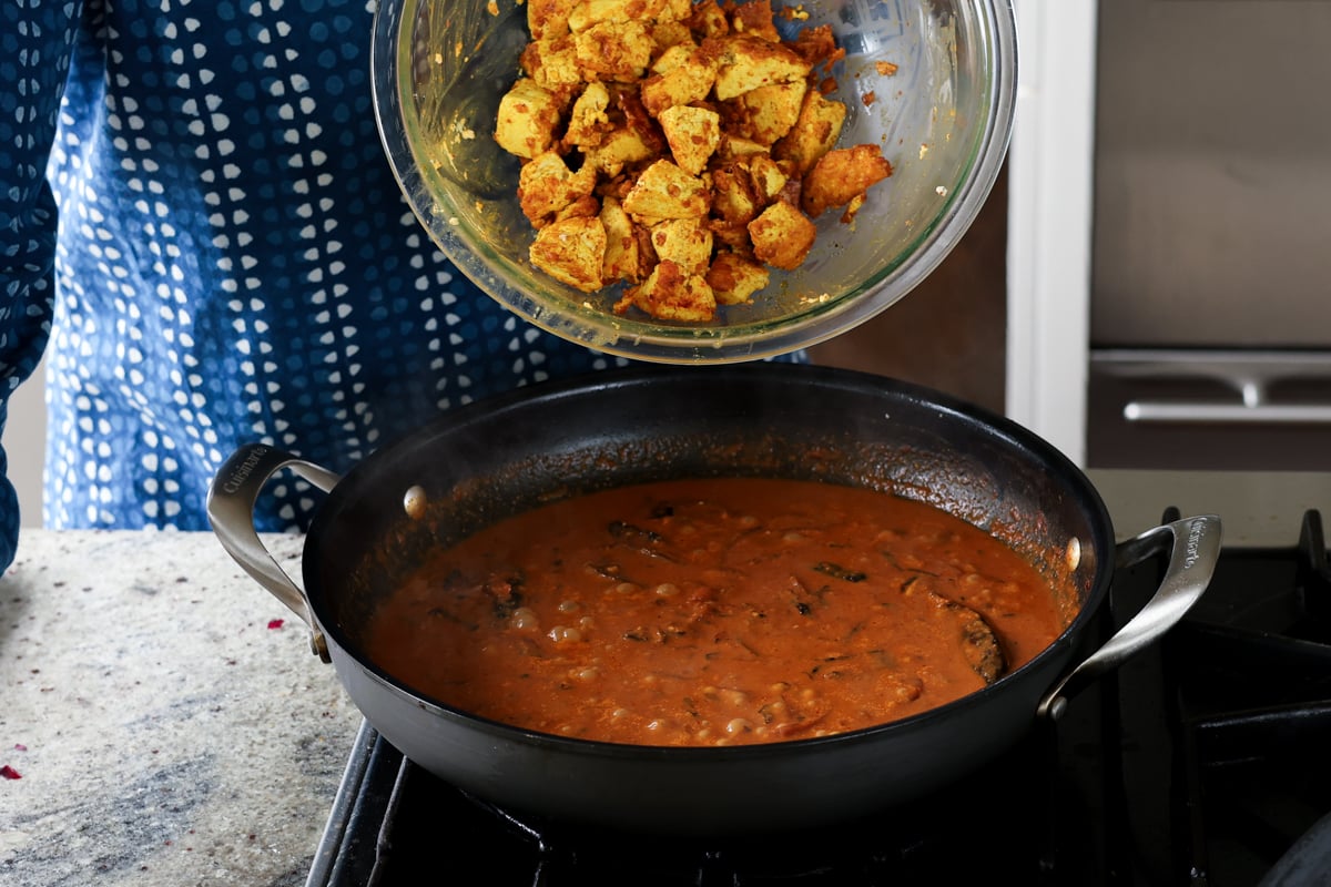 adding tofu to kosha mangsho sauce in the pan