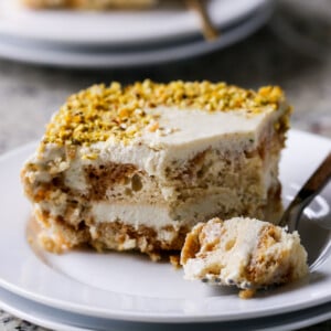 slice of Indian tiramisu on a white plate with a bite taken out